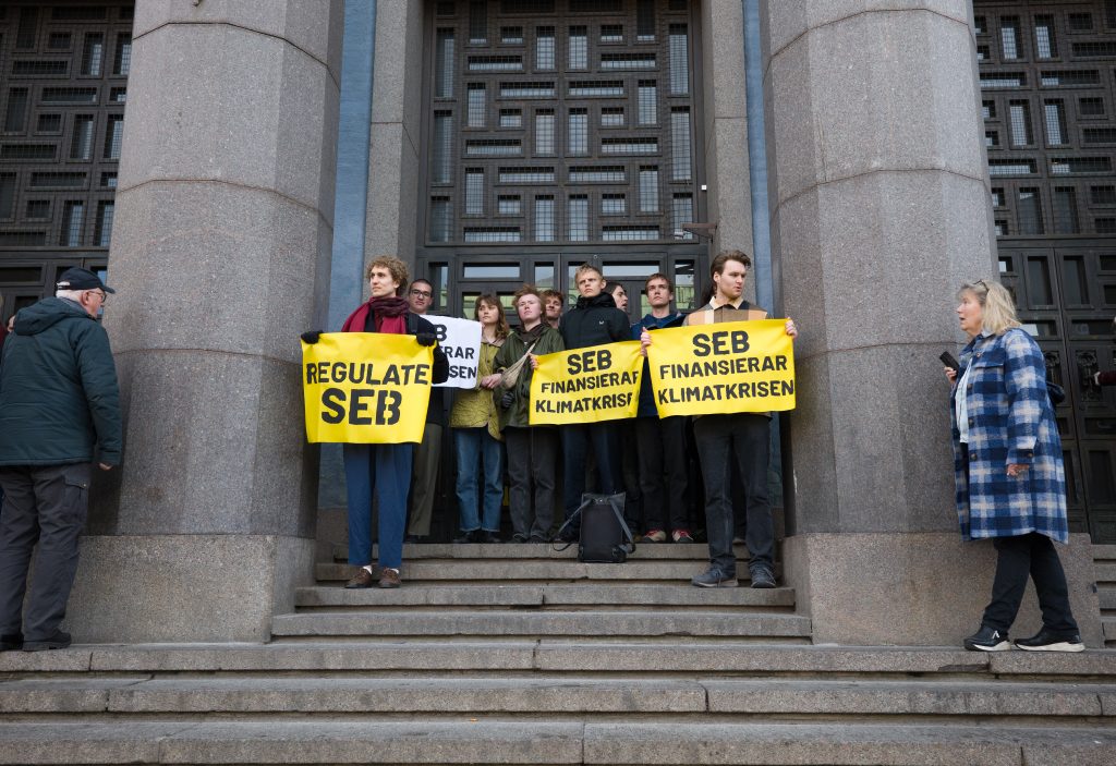 People standing with placards in front of bank